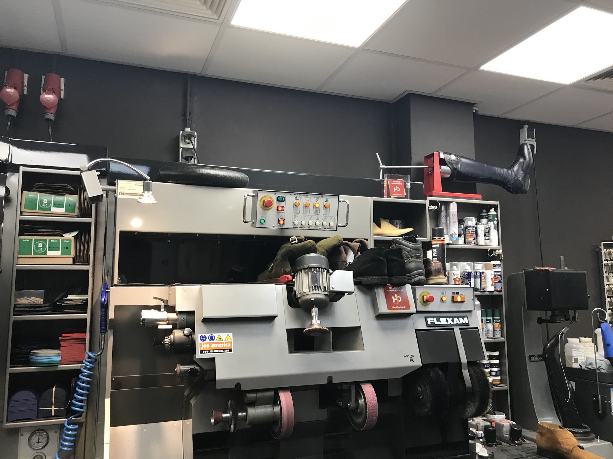 De werkplaats met de afwerkmachine waarop zolen en hakken worden bijgewerkt