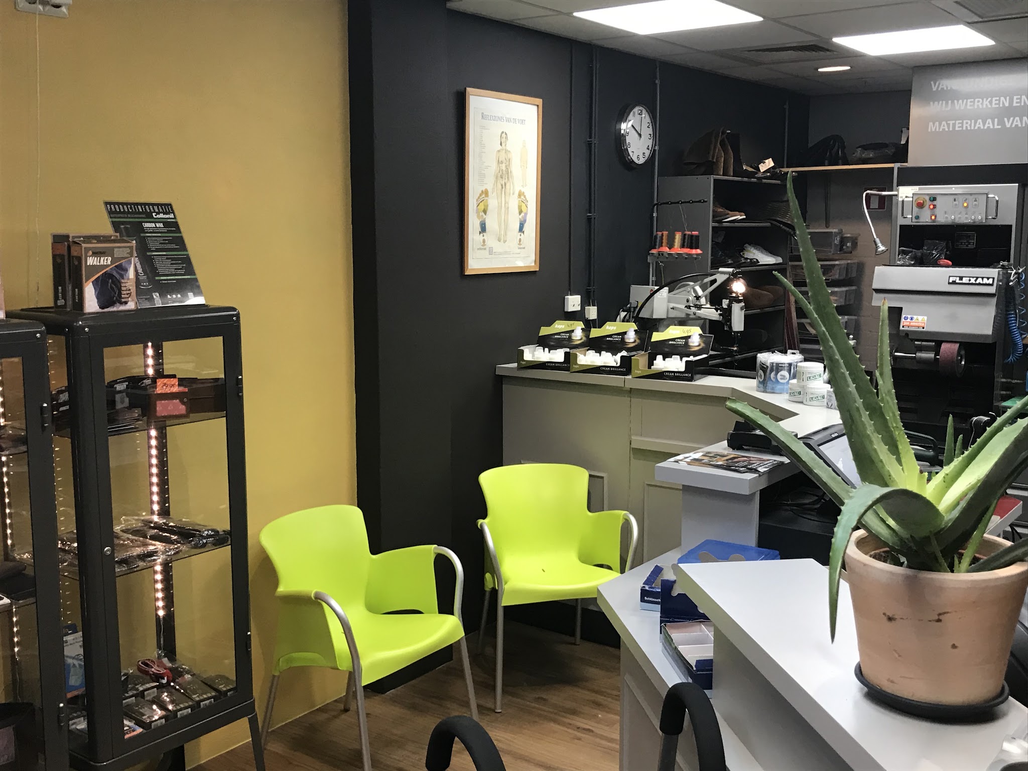 Wachtplek met stoelen en de werkplaats achter de toonbank