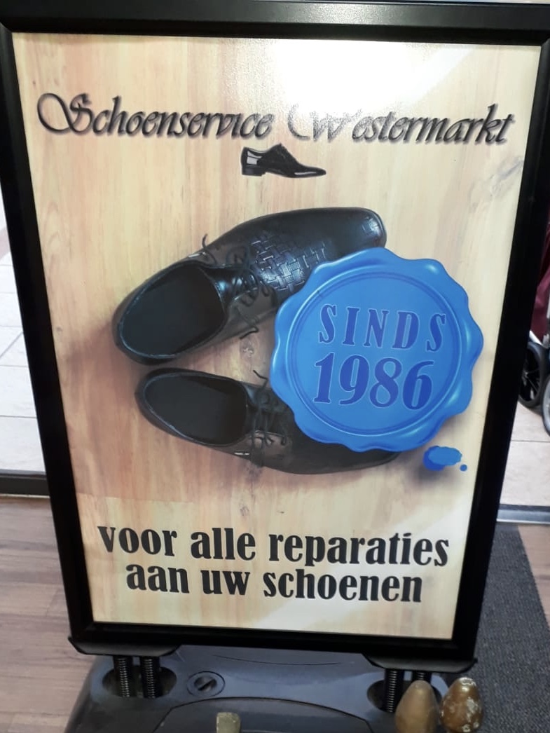 Stoepbord: Schoenservice Westermarkt, sinds 1986, voor alle reparaties aan uw schoenen